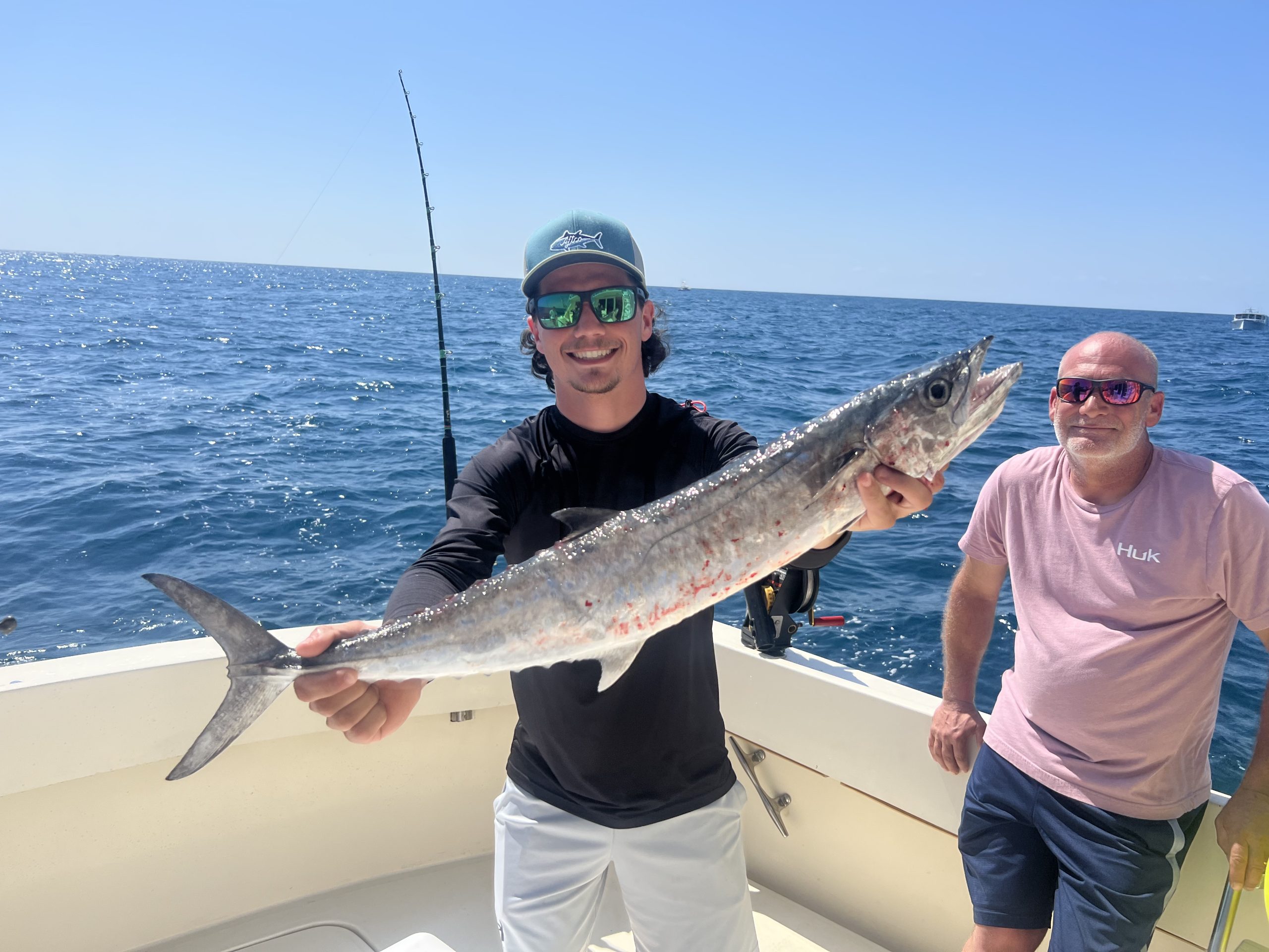 Man holds up a large kingfish while deep sea fishing in Florida