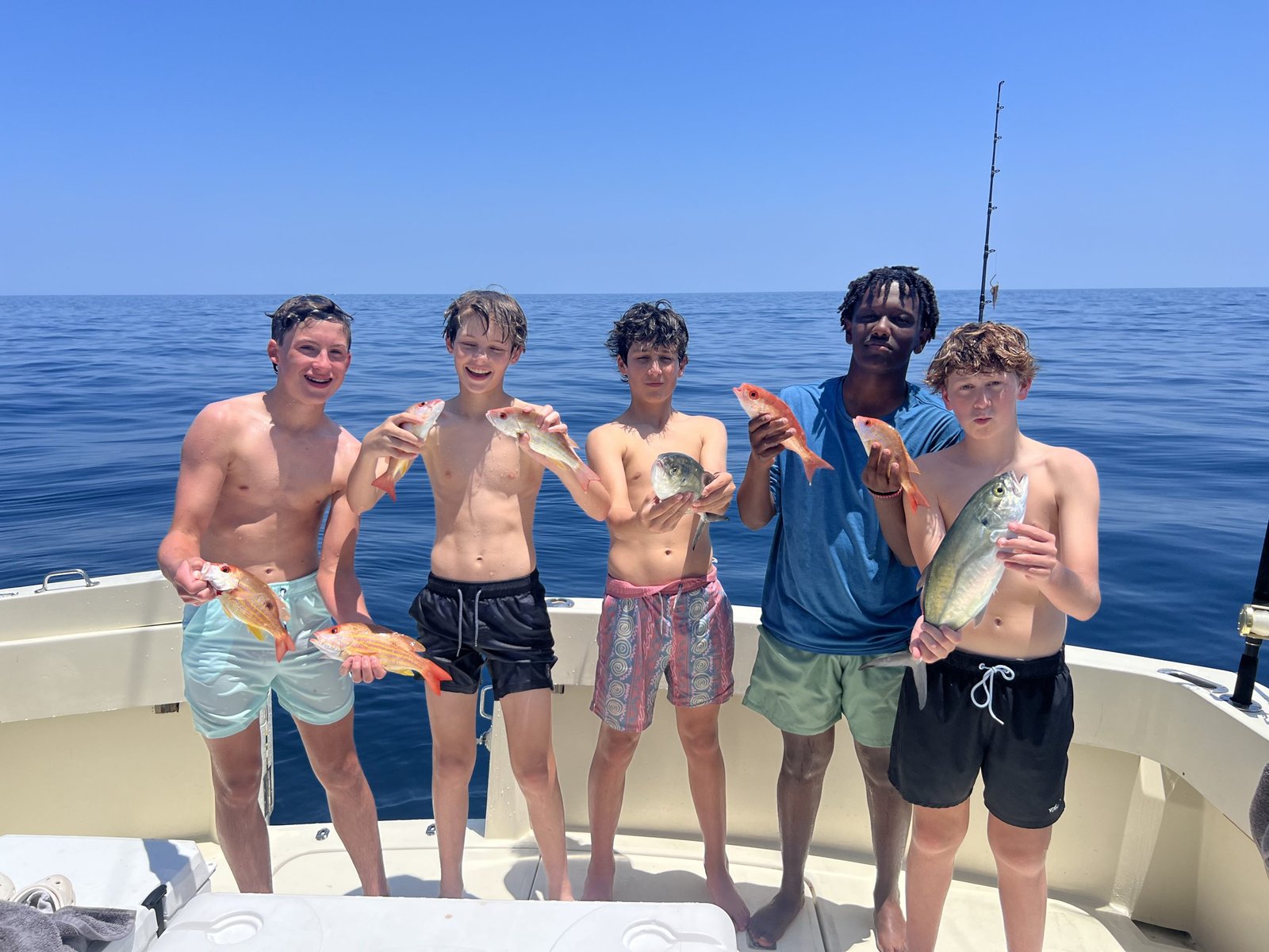 Five boys holding the snappers they caught will deep sea fishing in Florida